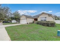 Residential home featuring a well-kept lawn, attractive landscaping, and a two-car garage in a friendly neighborhood at 3995 Sw 57Th Ct, Ocala, FL 34474