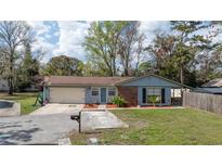 Charming one-story home with landscaped yard, attached garage, and inviting blue front door at 711 Briarwood Dr, Winter Springs, FL 32708