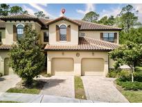Charming townhome with a terra cotta tile roof and two-car garage, with a brick paver driveway at 8141 Roseville Blvd, Davenport, FL 33896