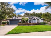 Charming single-story home with a well-manicured lawn and a two-car garage at 1008 Turtle Creek Dr, Oviedo, FL 32765