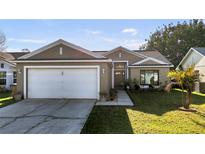 Charming one-story home with a well-manicured lawn and a two-car garage at 2417 Hybrid Dr, Kissimmee, FL 34758