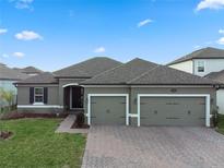 Beautiful single-story home with a well-manicured lawn, brick driveway, and a convenient two-car garage at 2620 Cedar Shake Ct, Oviedo, FL 32765