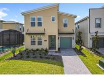 Modern two-story home featuring desert-tone walls, manicured lawn, stone accents, and attached garage at 2908 Protagonist St, Kissimmee, FL 34746