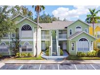 Charming condo building with a light green facade, white trim, and well-maintained landscaping at 3151 Britannia Blvd # A, Kissimmee, FL 34747