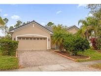 Charming single-story home showcasing a brick driveway, attached garage and well-maintained landscaping at 3927 Port Sea Pl, Kissimmee, FL 34746