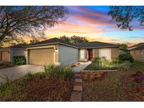 Charming one-story home with a well-manicured lawn and inviting red front door at 4135 Iveyglen Ave, Orlando, FL 32826