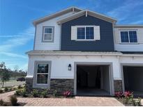 Charming two-story home with a two-car garage, brick paved driveway, and tasteful landscaping at 5116 Rain Shadow Dr, St Cloud, FL 34772