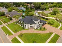 Expansive aerial shot showcases the landscaped grounds and circular brick driveway of this estate at 5447 Brookline Dr, Orlando, FL 32819