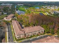 Aerial view of condos near a golf course, lakes, and mature trees at 706 Westpark Way # 203, Celebration, FL 34747