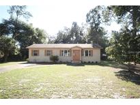 Charming single-story home features a well-maintained lawn and a classic front door with decorative shutters at 9 Lake Dr, Debary, FL 32713