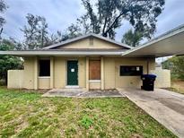 Modest single-story home with a carport and a simple landscaped yard at 115 S Lake Pleasant Rd, Apopka, FL 32703