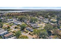 An aerial view of a charming community with mature trees and a lake in the background at 17529 Eve Dr, Montverde, FL 34756