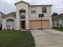 Two-story home with two car garage, well-maintained lawn, and a basketball hoop on the driveway at 2133 Korat Ln, Maitland, FL 32751