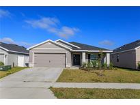 Charming single-story home featuring a well-manicured lawn and an attached two-car garage at 2447 Matterhorn Trl, Davenport, FL 33837