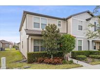 Charming two-story townhouse features well-maintained landscaping, including neatly trimmed hedges and vibrant flowering plants at 2682 Mead Ave, St Cloud, FL 34771