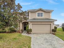 Charming two-story home with a well-manicured lawn and beautiful curb appeal at 302 Vista Loop, Davenport, FL 33897