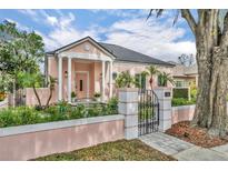 Charming home featuring columns, a black roof, and decorative plants surrounded by privacy walls at 335 Beloit Ave, Winter Park, FL 32789