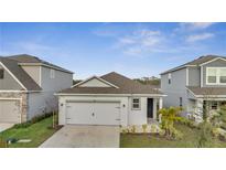 Charming single-story home featuring a gray exterior, attached garage, and manicured front yard at 4057 Sagefield Dr, Harmony, FL 34773