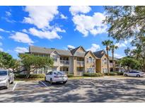 Apartment building exterior featuring multiple units, balconies, and ample parking spaces at 1015 S Hiawassee Rd # 3514, Orlando, FL 32835