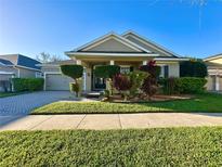 Charming one-story home with manicured lawn, trimmed bushes, and a paver driveway at 13226 Zori Ln, Windermere, FL 34786