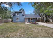 Charming two-story home featuring a covered front porch, blue siding, and a well-maintained yard at 137 Stevens Ave, Chuluota, FL 32766