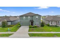 Two-story home with a two-car garage, neutral-colored exterior, well-manicured lawn and landscaping at 1629 Hill Park Dr, Deltona, FL 32725