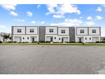 Modern townhomes feature a clean design with stone accents and a well-maintained green space at 205 Famagusta Dr, Davenport, FL 33896