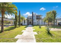 Modern two-story home featuring a manicured lawn and distinctive walkway at 34500 Tree Frog Ln, Eustis, FL 32736