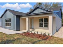 Charming single-Gathering home with light tan stucco, blue vertical siding, and inviting front porch at 355 Anderson Dr, Groveland, FL 34736