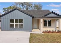 Charming single-story home featuring a modern facade with a combination of vertical siding and stucco elements at 355 Anderson Dr, Groveland, FL 34736