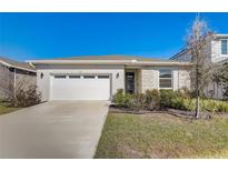 Charming single-story home with a two car garage, stone accents, and freshly manicured landscaping at 362 Sofia Ln, Lake Alfred, FL 33850