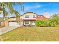 Charming two-story home featuring a brick facade, well-maintained lawn, and a two-car garage at 5108 Avignon Ct, Orlando, FL 32839