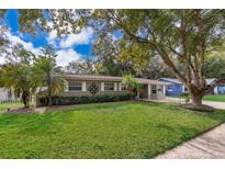 Charming single-story home with a well-manicured lawn, mature trees, and neutral exterior paint at 5214 E Kaley St, Orlando, FL 32812