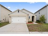 Charming single-story home featuring a two-car garage and tidy landscaping at 6745 Huntleigh Hammock Rd, Harmony, FL 34773