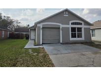 Charming single Gathering home with attached garage and well-maintained front yard at 6856 Ebans Bnd, Orlando, FL 32807