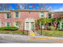 Charming townhome featuring a brick facade, green shutters, and a well-maintained landscaped front yard at 127 Georgetown Dr # 127, Casselberry, FL 32707