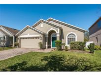 Charming single-story home featuring a well-manicured lawn and attached two-car garage at 15341 Urbino Ln, Orlando, FL 32828