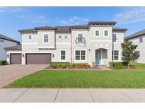 Stunning two-story home features a manicured lawn, three car garage, and elegant architectural details at 1595 Juniper Hammock St, Winter Garden, FL 34787