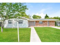 Charming single-story home with a well-manicured lawn and brick accents at 2021 Canal Rd, Deltona, FL 32738