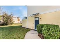 Inviting front entrance with a blue door, manicured bushes, and a well-maintained lawn at 2023 Grand Oak Dr, Kissimmee, FL 34744