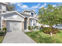 Charming two-story home with stone accents, well-manicured lawn, and attached garage at 221 Chippendale Ter, Oviedo, FL 32765