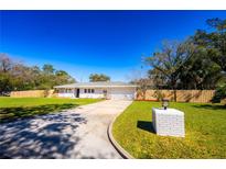 Charming single-story home with a well-maintained lawn and a long, curved driveway at 2401 S Myrtle Ave, Sanford, FL 32771