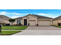 Inviting single-story home with a well-manicured lawn and two-car garage at 3504 Cayugas Loop, St Cloud, FL 34772