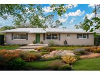 Charming single-story home featuring a landscaped front yard with native plants and stepping stone pathway at 4898 Meadow Dr, St Cloud, FL 34772