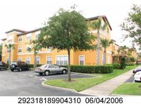 Multi-story yellow condo building with well-maintained landscaping, sidewalks, and ample parking at 5459 Vineland Rd # 4310, Orlando, FL 32811