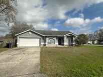 Charming single-story home with a two-car garage and a well-maintained lawn at 7277 Pebble Pass Loop Loop, Lakeland, FL 33810