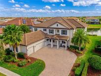 Stunning two-story home with a three-car garage, a large driveway, lush landscaping, and a beautiful tile roof at 7515 John Hancock Dr, Winter Garden, FL 34787