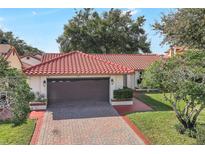 Charming single-story home featuring a red tile roof and brick driveway at 8218 Borgia Ct, Orlando, FL 32836