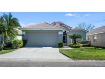 Charming single-story home showcasing a manicured lawn, tile roof, and a spacious two-car garage at 944 Glen Abbey Cir, Winter Springs, FL 32708