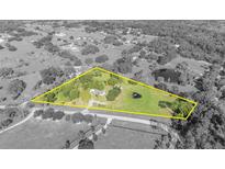Aerial view of a house on a large, green lot featuring a pond and surrounded by trees at 1350 N Hart Rd, Geneva, FL 32732